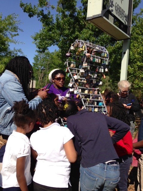 Teacher Morgan Ealy encourages tudents to make "your wish for Rockefeller Elementary" as she snaps on the school's wish lock on a recent field trip to the garden.